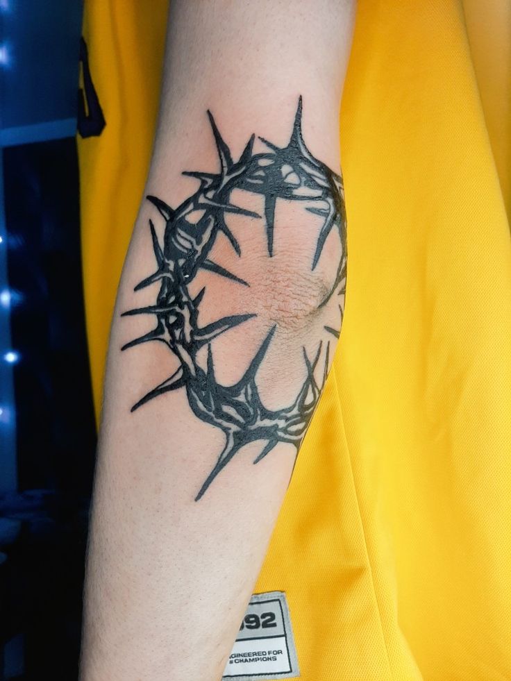 a man with a crown tattoo on his arm