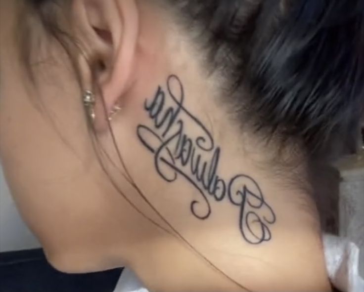 a woman with a tattoo on her neck has the word poluliga written in cursive script