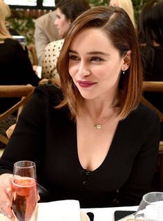 a woman sitting at a table with a glass of wine