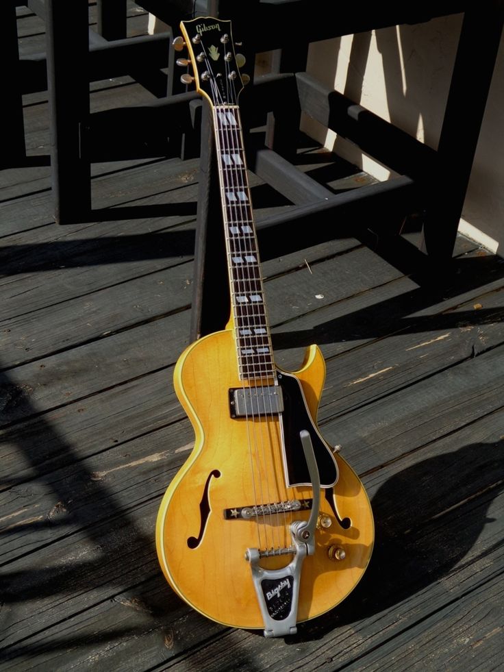 a yellow guitar sitting on top of a wooden floor