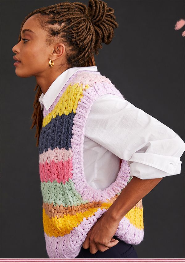 a woman with dreadlocks wearing a multicolored vest