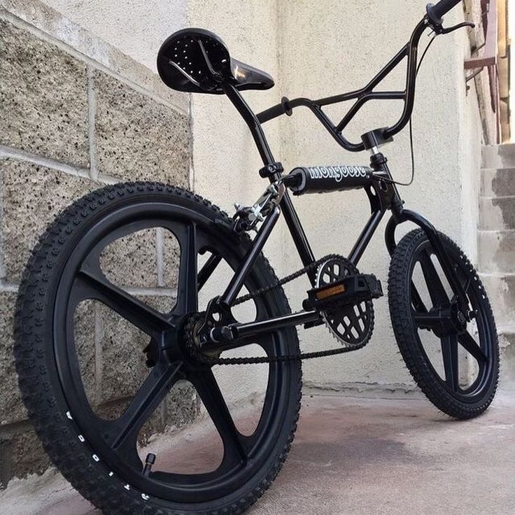 a black bicycle parked on the side of a building