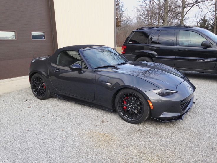 a gray sports car parked in front of a garage