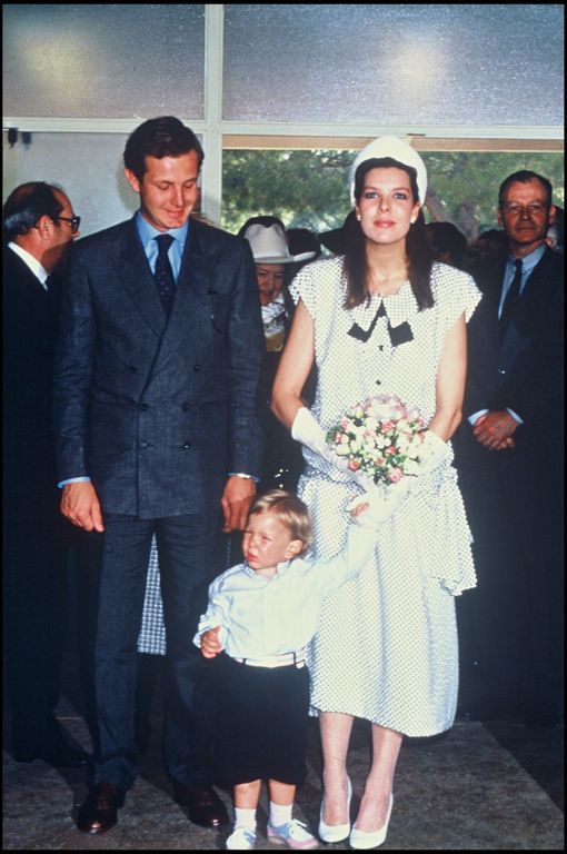 a man and woman standing next to each other with a small child in front of them