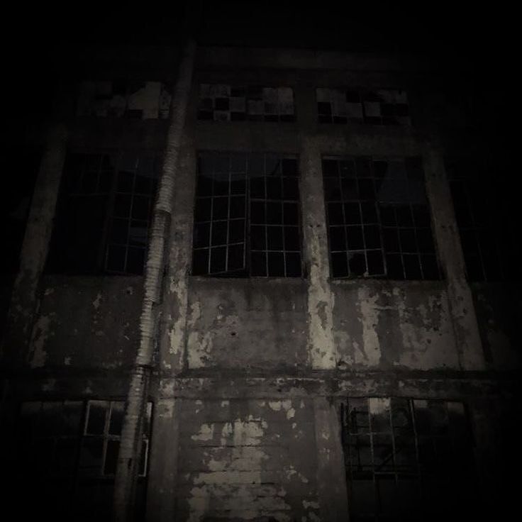 an old building with barred windows at night