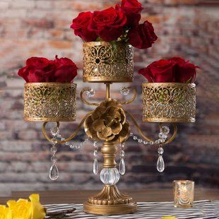 a gold candelabra with red roses on it