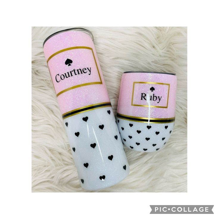 two pink and white coffee mugs sitting on top of a fur rug with hearts