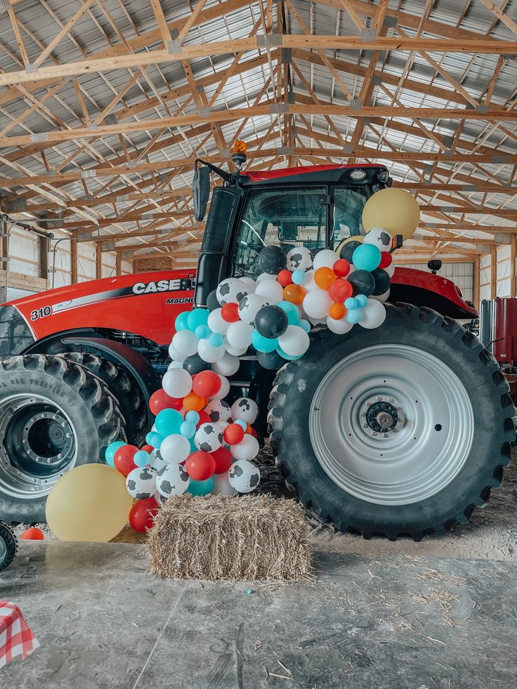 a tractor decorated with balloons in a barn