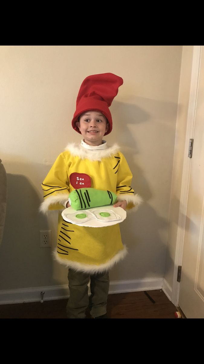 a little boy dressed up as a cat in the hat holding a plate and smiling