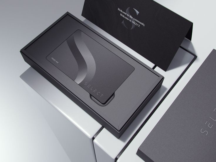 two black and silver business cards sitting on top of a white table next to each other