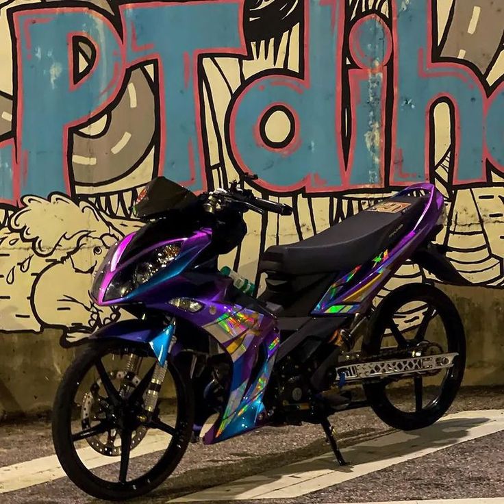 a motorcycle parked in front of a graffiti covered wall