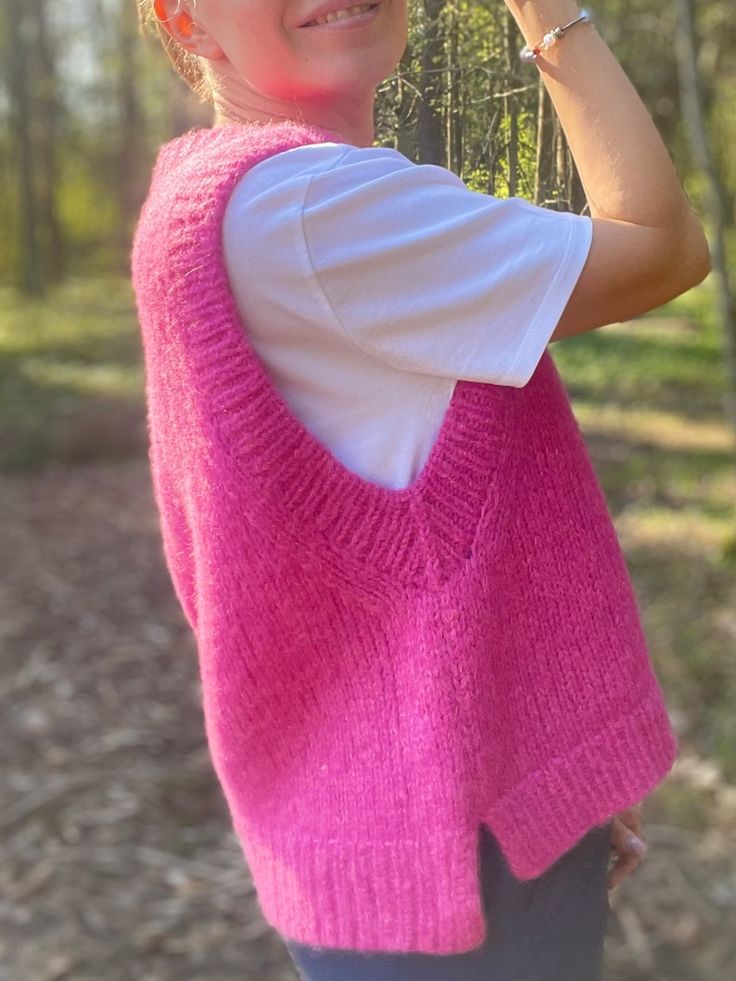 a woman wearing a pink sweater and sunglasses