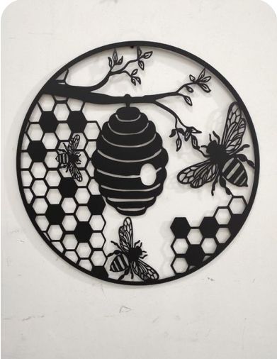 a circular metal wall hanging with bees and honeycombs