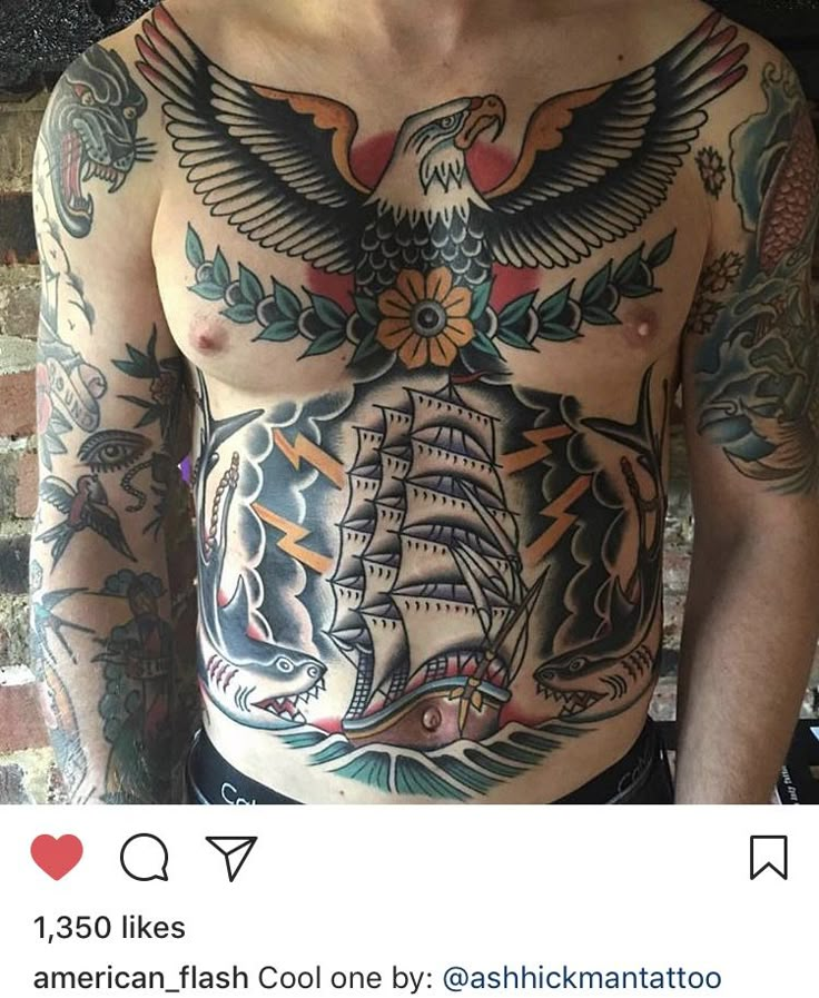 a man with an eagle and ship tattoo on his chest is standing in front of a brick wall