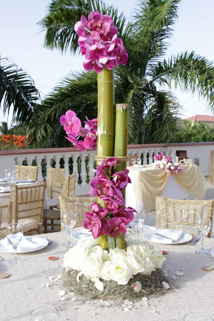 a tall vase filled with flowers on top of a table