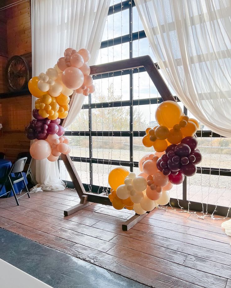 an arch made out of balloons in front of a window