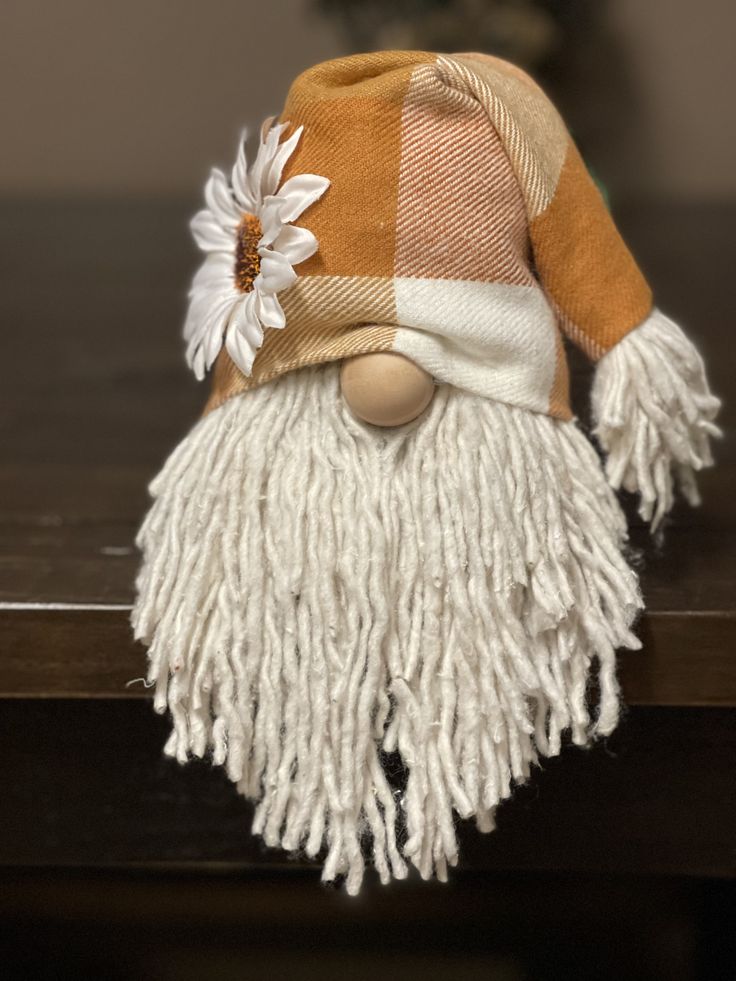 a close up of a stuffed animal on a table with a flower in it's hair