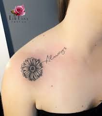 a woman with a tattoo on her shoulder has a name and a flower in it