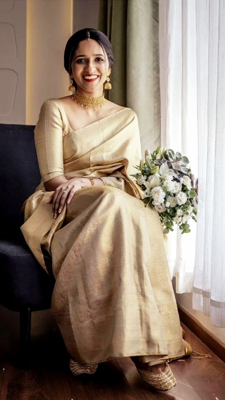 a woman sitting on top of a chair next to a flower bouquet in front of a window