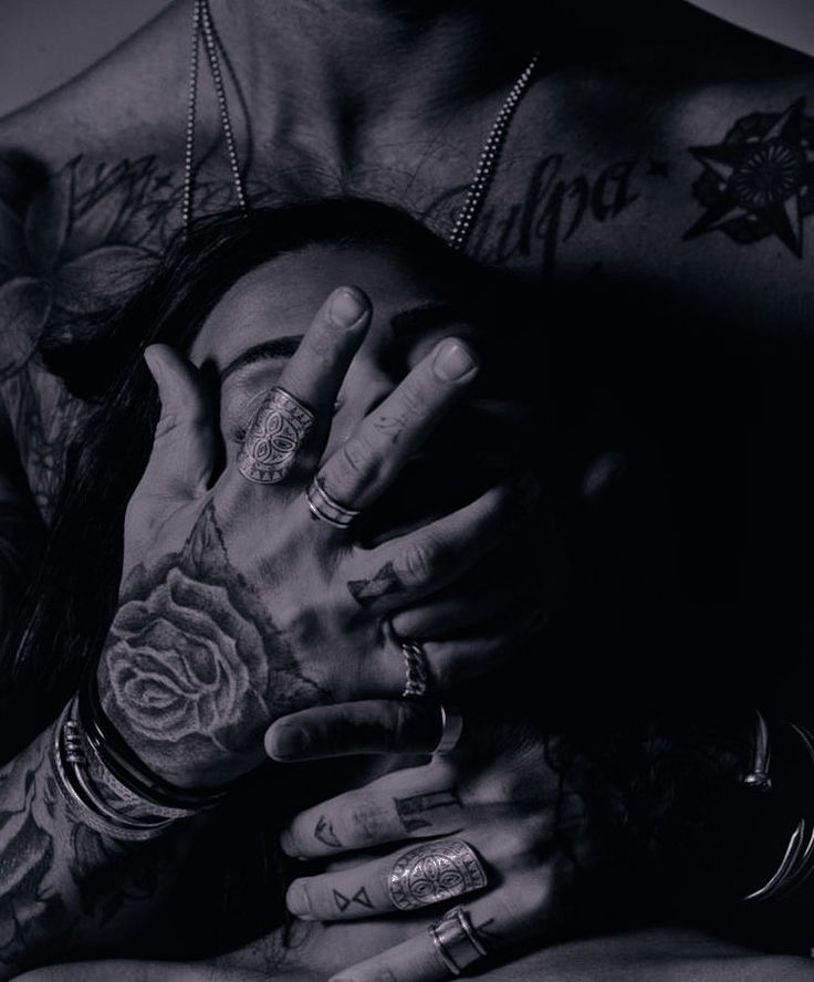 a man with tattoos covering his face and hands