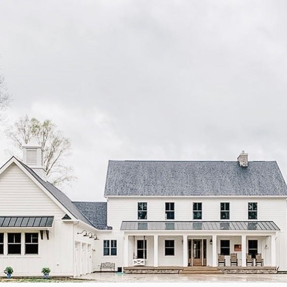 a large white house sitting on top of a lush green field