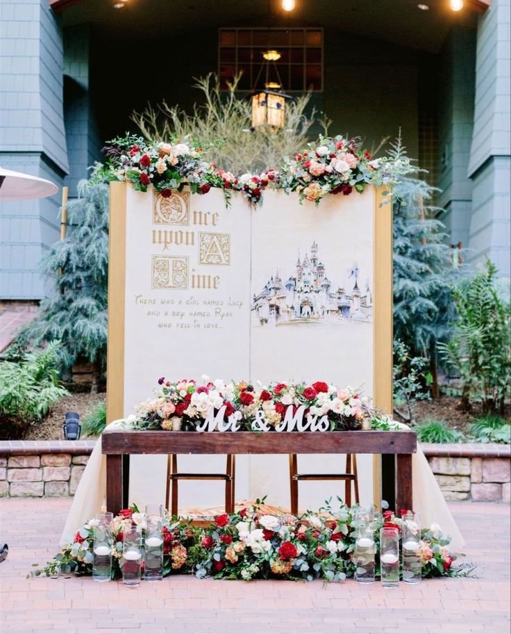 a table with flowers and candles on it in front of a sign that says welcome to the wedding