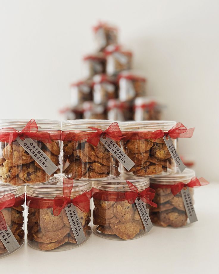 several jars filled with cookies sitting on top of a white table next to each other