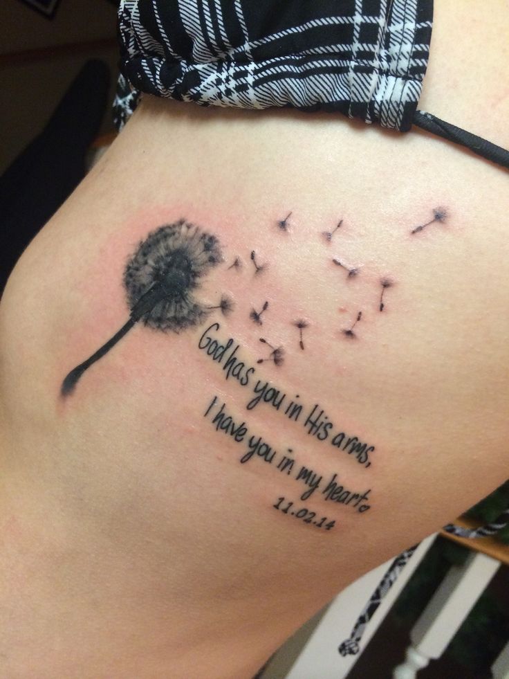 a woman's stomach with a dandelion tattoo on it that says, god is your in his arms i have you in my heart