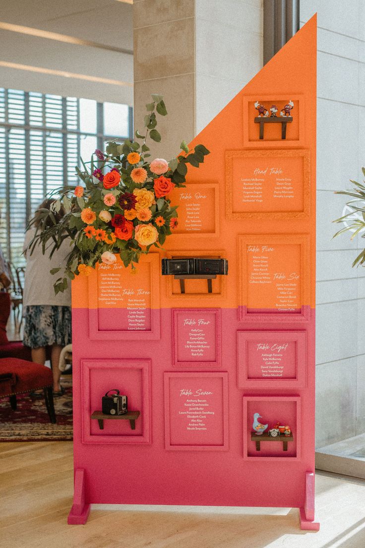 an orange and pink display with flowers on it