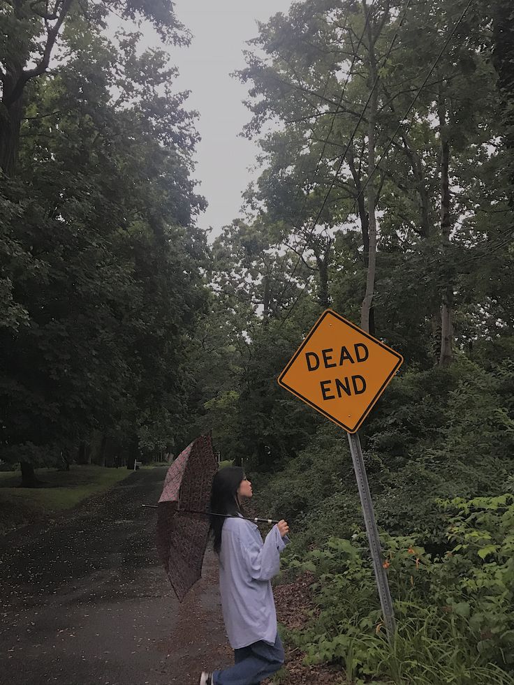 Asian teen girl with an umbrella on a rainy day next to a dead end sign in a forest. She is wearing baggy jeans and an oversized sweater Roadside Photoshoot, Gloomy Day Photoshoot, Rainy Day Photoshoot, Feminine Poses, Dead End Sign, Rainy Photoshoot, Formal Dress Pants, Friend Photography, Dead End