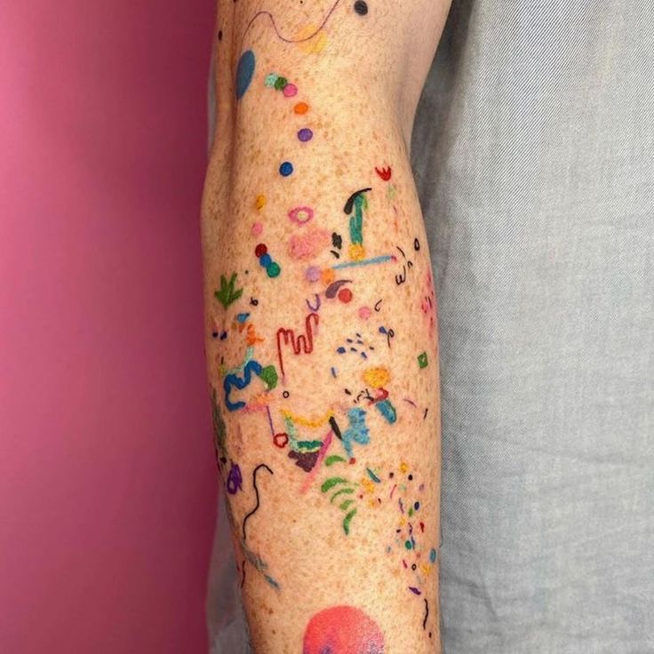 a man's arm covered in lots of different colored sprinkles and dots