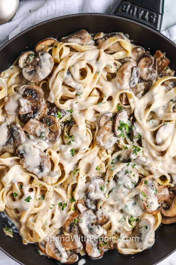 a skillet filled with pasta and mushrooms