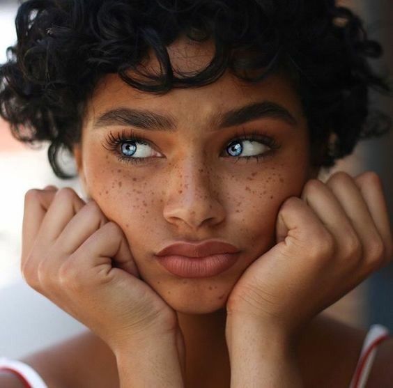 a woman with freckles on her face posing for the camera