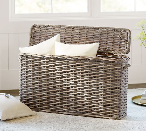 a wicker basket with two white pillows