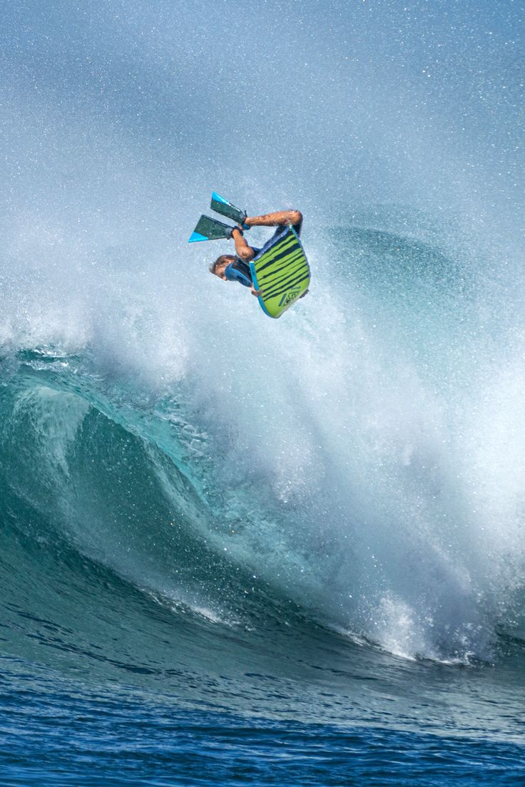 a man riding a wave on top of a surfboard in the air over water