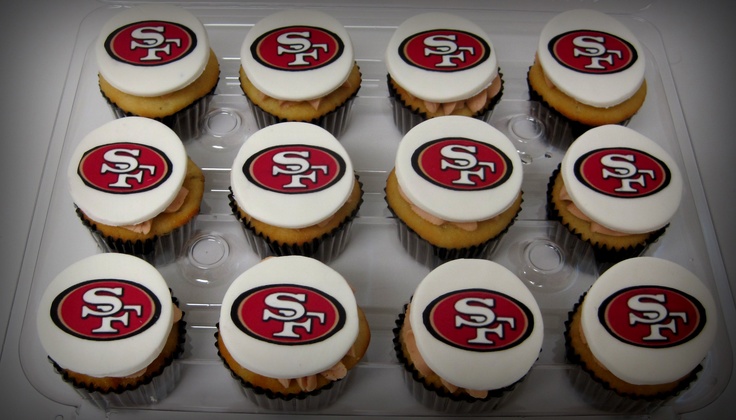 twelve cupcakes with frosting and the san francisco logo on them