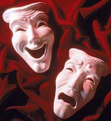 two white masks with mouths open on a red cloth covered ground, one is smiling and the other has his mouth wide open