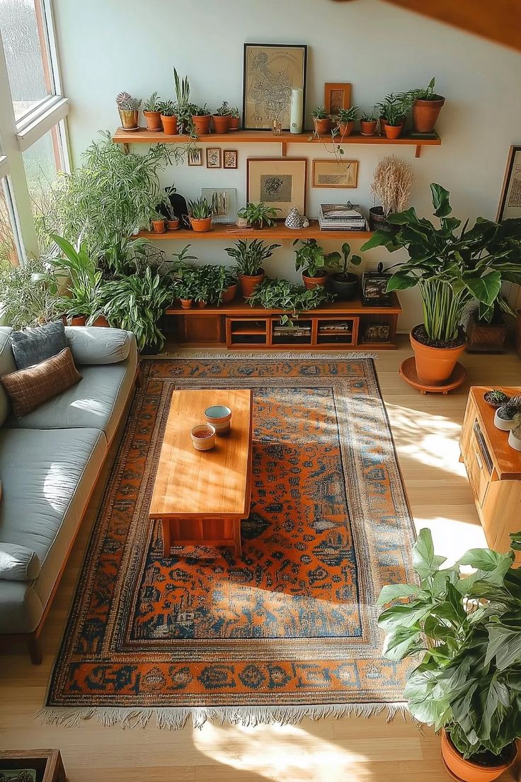 a living room filled with lots of plants next to a couch and coffee table on top of a rug