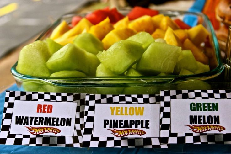 there are many different types of fruit in the bowl on the table, including melons and pineapples