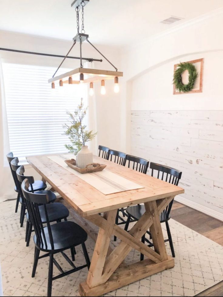 a dining room table with chairs and a vase on it