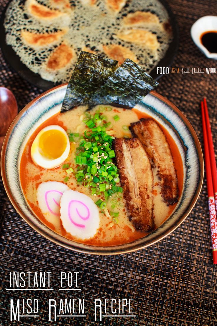 a bowl of ramen with meat and vegetables on it next to chopsticks