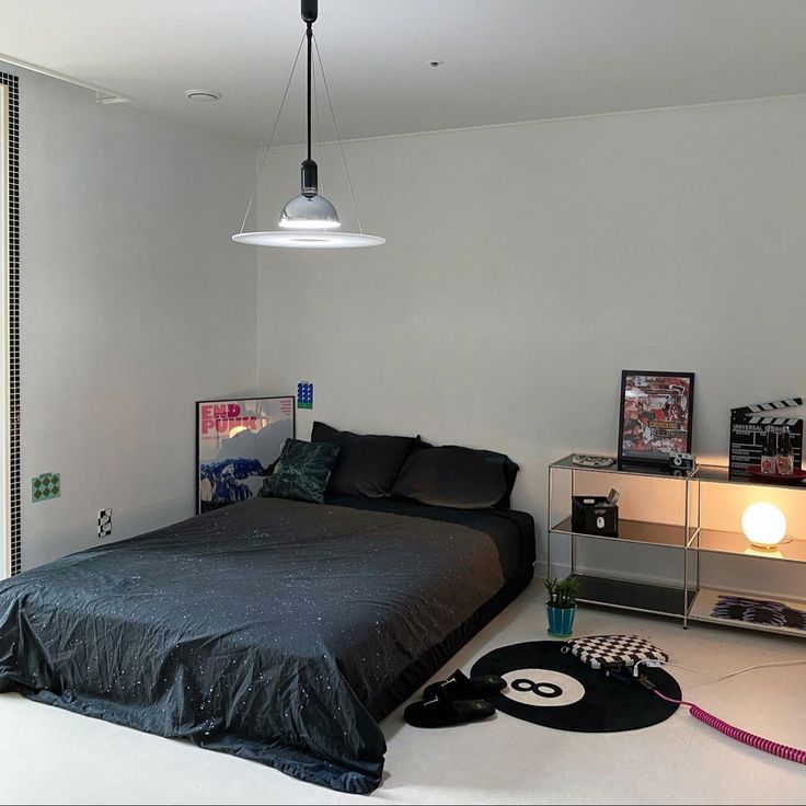 a bedroom with a black bed and white walls