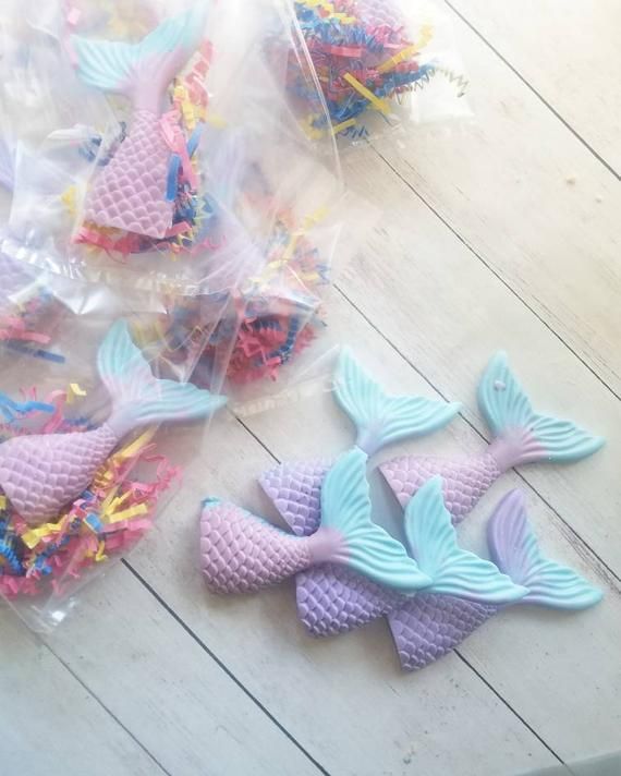 several little toy mermaids are on the floor next to some plastic bagged toys