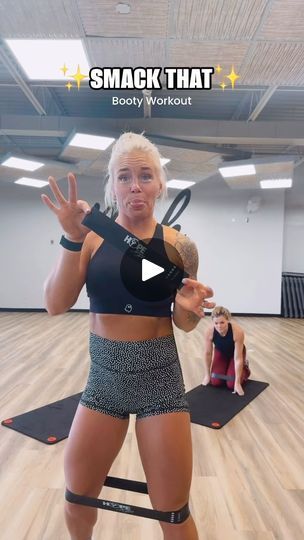 a woman standing on top of a yoga mat in a gym with her hands up