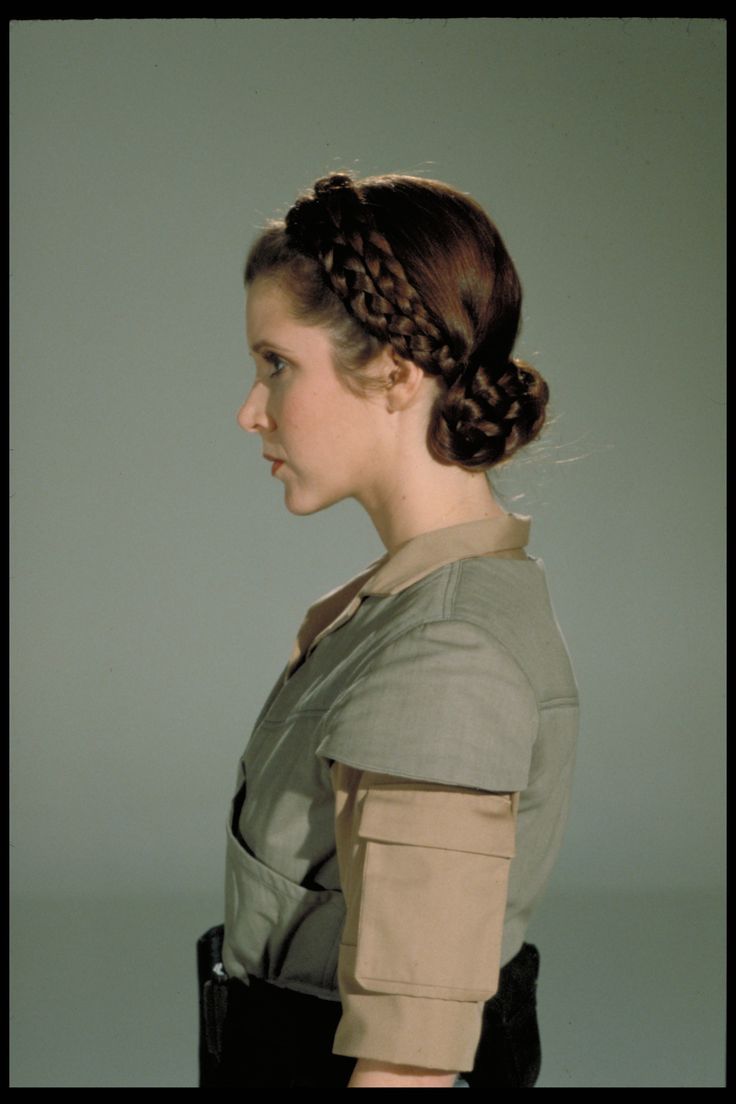 a woman with braids in her hair wearing a star wars uniform and looking off to the side