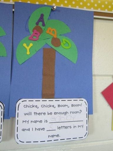 two children's crafts hanging on the wall in front of a bulletin board with letters and numbers