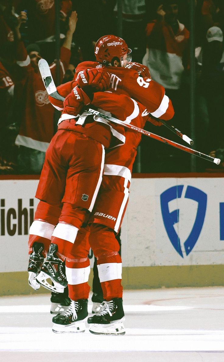 two hockey players hugging each other on the ice