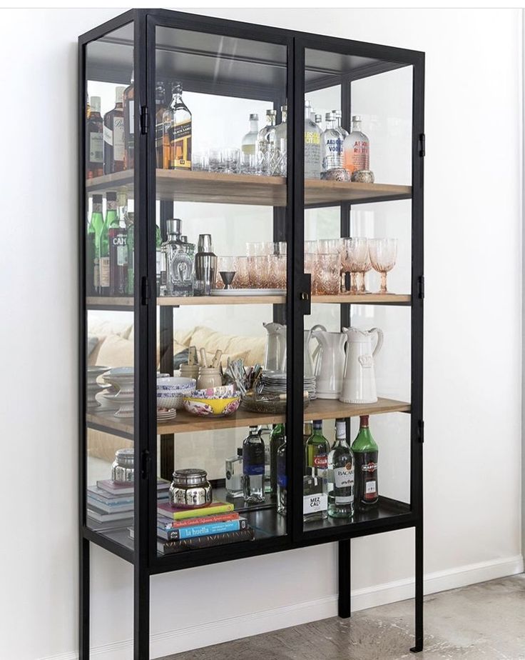 a glass display case filled with bottles and glasses