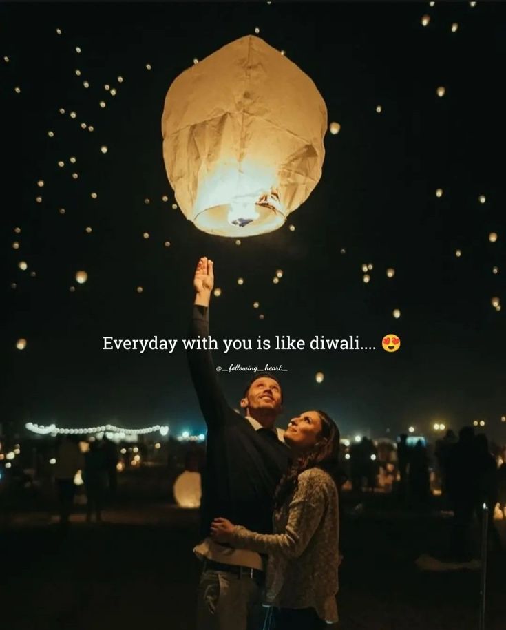 a man and woman holding up a paper lantern in the air with words above them