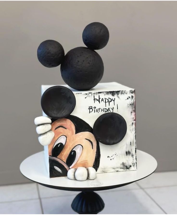 a mickey mouse birthday cake on a pedestal